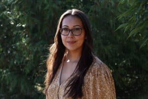 Woman with long brown hair and wearing glasses