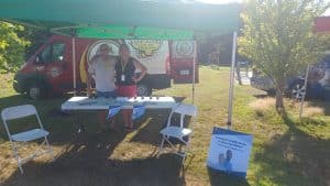 Picture of staff at an information table about the Health Connect Registry at Music at the Park